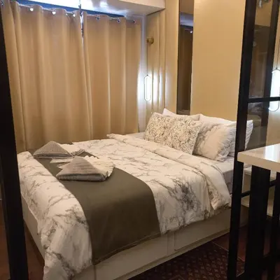 a bed in a small room with a window at Luxurious Condotel at the heart of Makati in Manila