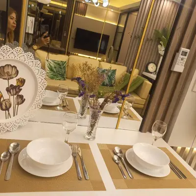 a table with plates and silverware on a table at Luxurious Condotel at the heart of Makati in Manila