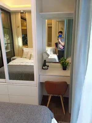 a man taking a picture of a bedroom with a mirror at Luxurious Condotel at the heart of Makati in Manila
