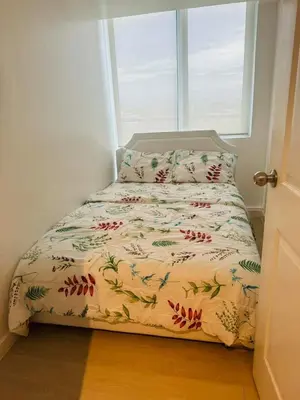 a small bed in a room with a window at Azure Urban Resort in Manila