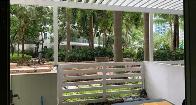 a balcony with a white fence and palm trees at Azure Urban Resort in Manila