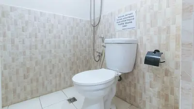 a bathroom with a toilet and a sign on the wall at 4720 Silverio Suites Paranaque City in Manila