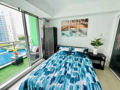 a bedroom with a bed and a large window at Azure Positano Tower Beach Vibe in Manila