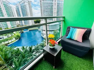 a balcony with a couch and a swimming pool at Azure Positano Tower Beach Vibe in Manila