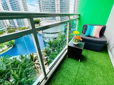a balcony with a couch and a view of the water at Azure Positano Tower Beach Vibe in Manila