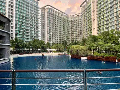 a large swimming pool in front of tall buildings at Azure Positano Tower Beach Vibe in Manila