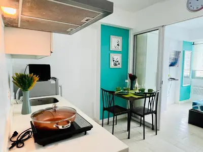 a kitchen with a sink and a table with chairs at Azure Positano Tower Beach Vibe in Manila