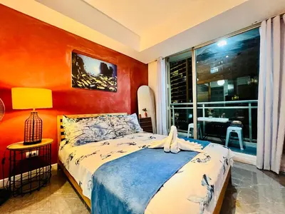 a bedroom with a bed and a large window at Scr Summer Vibe Netflix Balcony in Manila