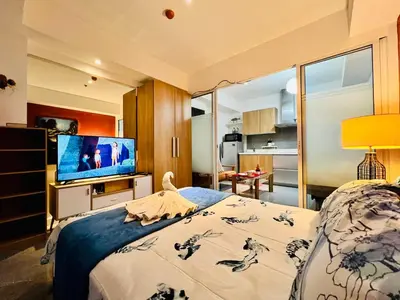 a bedroom with a bed and a tv in a room at Scr Summer Vibe Netflix Balcony in Manila