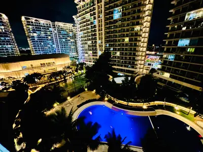 a view of a city at night with a pool at Scr Summer Vibe Netflix Balcony in Manila