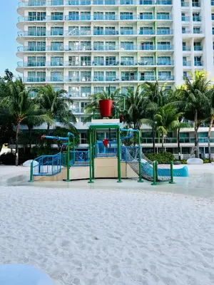 a playground on the beach in front of a large building at Scr Summer Vibe Netflix Balcony in Manila