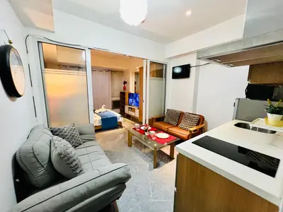 a living room with a couch and a kitchen at Scr Summer Vibe Netflix Balcony in Manila