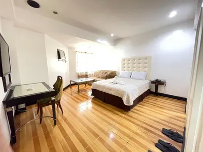 a bedroom with a bed and a desk and a desk at Town and Country Hotel V Mapa in Manila