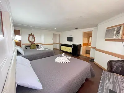 a hotel room with two beds and a television at Town and Country Hotel V Mapa in Manila