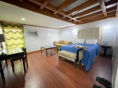 a bedroom with a bed and a couch and a table at Town and Country Hotel V Mapa in Manila