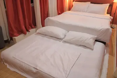 two beds with white sheets and pillows in a room at A2J BGC Luxury 2BR Loft Near Burgos Circle, Malls in Manila