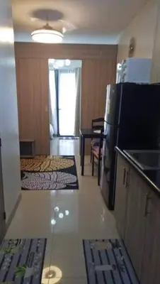 a room with a kitchen with a refrigerator and a table at MOA Shore 2 1BR with Balcony WiFi Netflix Pool 4Pax in Manila