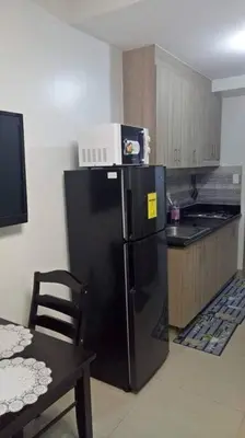 a kitchen with a black refrigerator with a microwave on top at MOA Shore 2 1BR with Balcony WiFi Netflix Pool 4Pax in Manila