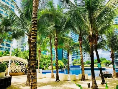 a group of palm trees in front of a building at S-a-f-e Haven Resort Staycation in Manila