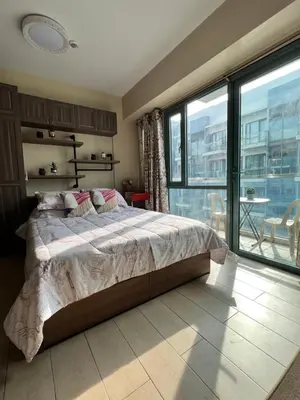 a bedroom with a large bed and a large window at Studio at Newport World Airport Area Prime Location in Manila