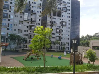 a playground in front of a tall building at Monteluce 2 BR LOFT with pool 825 in Silang