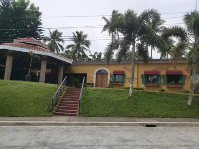 a yellow house with palm trees in front of it at Monteluce 2 BR LOFT with pool 825 in Silang