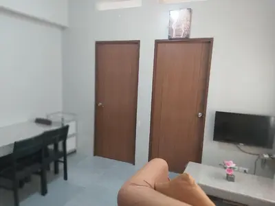 a room with a piano and a table with a television at Affordable Tagaytay Monteluce 2 BR with Pool G28 in Silang