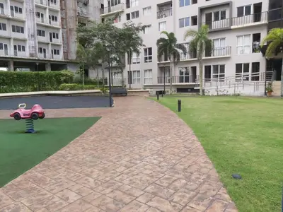 a playground in front of a large apartment building at Affordable Tagaytay Monteluce 2 BR with Pool G28 in Silang