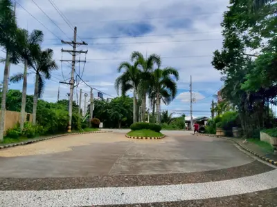 an empty driveway with palm trees in the distance at Affordable Tagaytay Monteluce 2 BR with Pool G28 in Silang