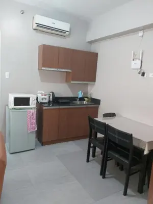 a kitchen with a table and a sink and a refrigerator at Affordable Tagaytay Monteluce 2 BR with Pool G28 in Silang