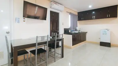 a kitchen with a table and chairs in a room at 153 Silverio Suites Paranaque City in Manila