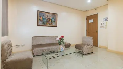 a living room with two chairs and a glass table at 153 Silverio Suites Paranaque City in Manila