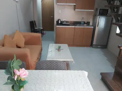 a living room with a couch and a table at Affordable Tagaytay Monteluce 2 BR Loft with pool 32 in Lalaan Primero