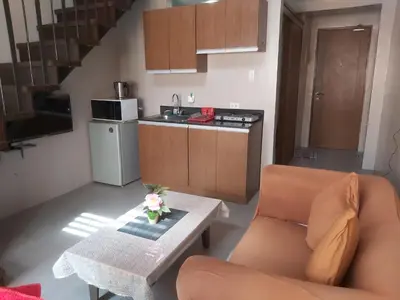 a kitchen with a couch and a table in a room at Affordable Tagaytay Monteluce 2 BR Loft with pool 32 in Lalaan Primero