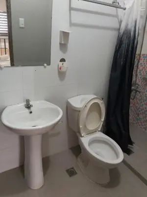 a bathroom with a white toilet and a sink at Affordable Tagaytay Monteluce 2 BR Loft with pool 32 in Lalaan Primero