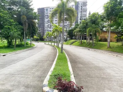 an empty street with palm trees and buildings at Affordable Tagaytay Monteluce 2 BR Loft with pool 32 in Lalaan Primero