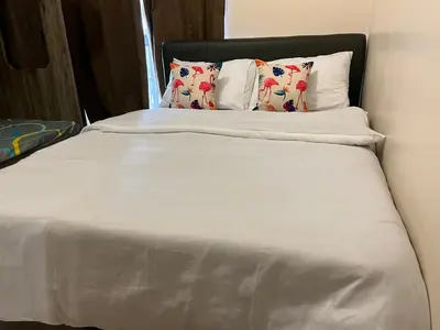 a bed with white sheets and pillows in a room at Ramiro Haven Staycation in Manila