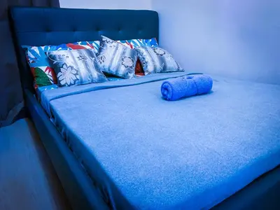 a blue bed with blue sheets and pillows on it at Ramiro Haven Staycation in Manila