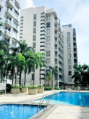 a swimming pool in front of a large apartment building at Luxury Condotel Across NAIA Manila Airport in Manila