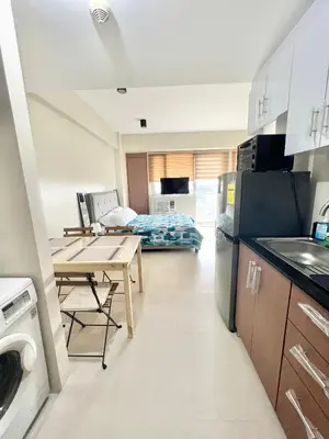 a kitchen and living room with a table and a couch at Luxury Condotel Across NAIA Manila Airport in Manila