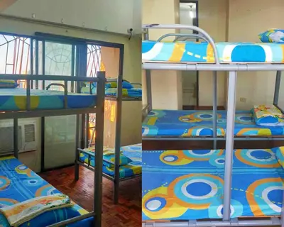 a couple of bunk beds in a room at Mang Ben Dormitory Pasay in Manila