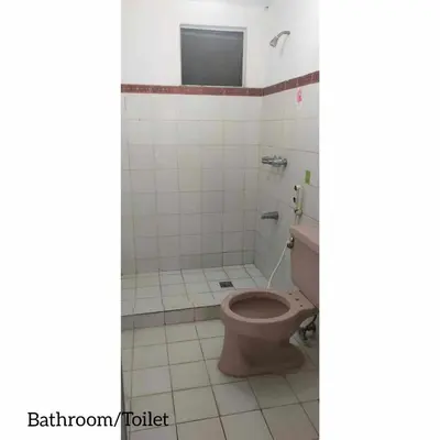 a bathroom with a toilet and a tiled floor at Mang Ben Dormitory Pasay in Manila
