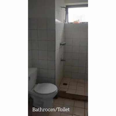 a bathroom with a toilet and a shower at Mang Ben Dormitory Pasay in Manila