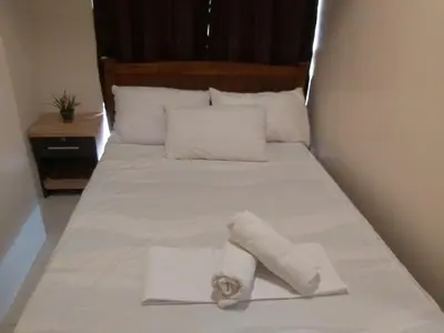 a white bed with a rolled up towel on it at Affordable Tagaytay Monteluce 1BR with Pool G10 in Lalaan Primero