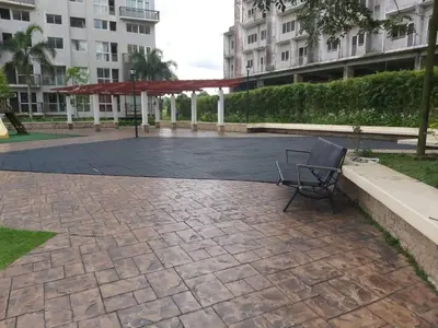 a chair sitting on a patio in front of a building at Affordable Tagaytay Monteluce 1 BR WITH POOL-224 in Lalaan Primero