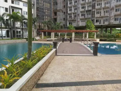 a walkway next to a pool in a building at Affordable Tagaytay Monteluce 1 BR WITH POOL-224 in Lalaan Primero