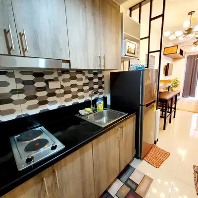 a kitchen with a sink and a refrigerator at S Residences MOA Condo Stunning Boutique Hotel Type T1 in Manila