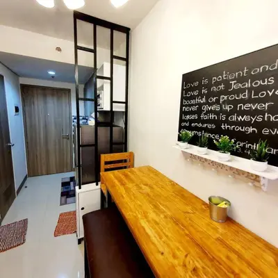 a wooden table in a room with a sign on the wall at S Residences MOA Condo Stunning Boutique Hotel Type T1 in Manila