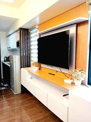 a living room with a large television on a wall at Air Residences Makati Condo Elegant Grand Hotel Type in Manila