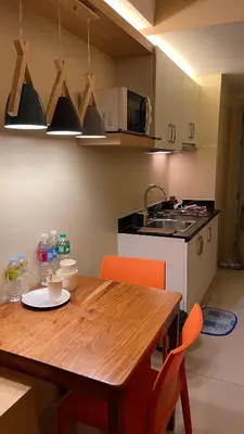 a kitchen with a wooden table and orange chairs at Netflix- Destina Stays at Jazz Residences Makati, MetroManila in Manila